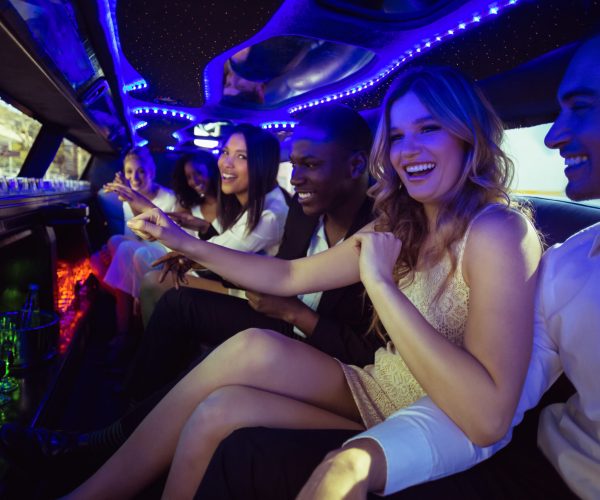 Happy friends chatting in limousine on a night out